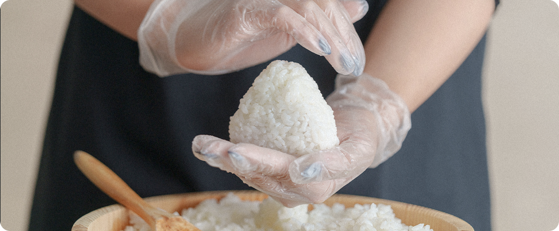 三角におにぎりを握る様子